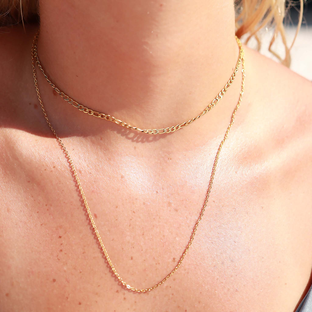 Close-up of a gold chain necklace on a person's neck